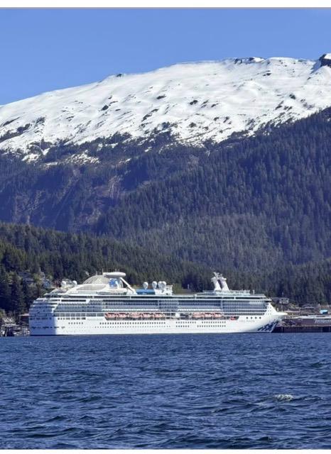 Cruise ship on the water beneath snow covered mountains
