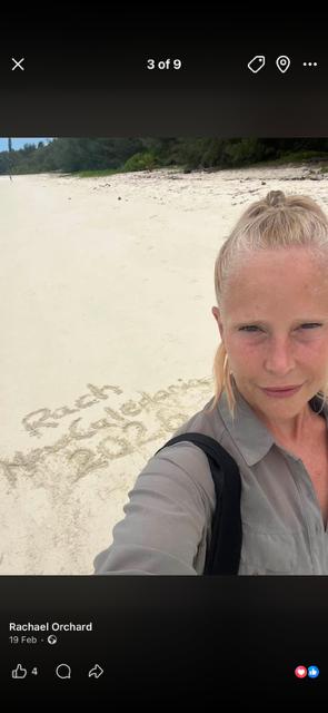 Rachael Orchard on a beach with Beach Walk Challenge written in the sand
